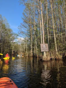 A picture of the canoe trail signage at Goodale State Park, kayakers can be seen padding in the background